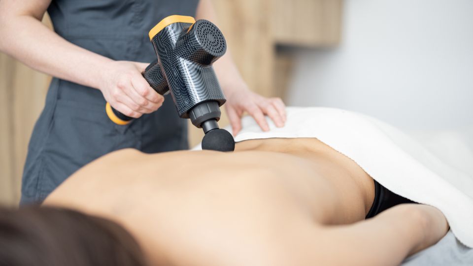 Egy masszírozógép használata a hát masszírozásához, relaxáló környezetben.