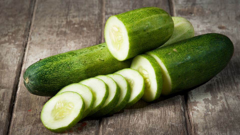 Friss uborka, szeletekre vágva, fából készült asztalon.