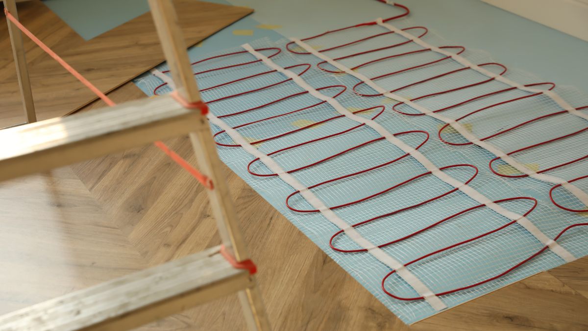 Elektromos padlófűtés telepítése, látható fűtőszálakkal és létrával.